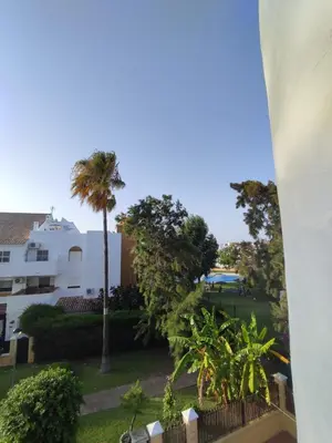 a view from the balcony of a building with palm trees at APARTAMENTO SEGUNDA PLANTA in Chiclana de la Frontera