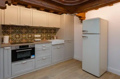 a kitchen with white cabinets and a refrigerator at Estudio Amor BRUJO by Cadiz4Rentals in Cádiz