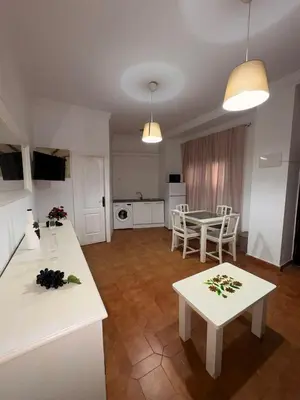 a kitchen and living room with a table and chairs at Casa Antonia II in Jerez de la Frontera