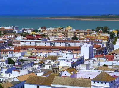 a city with white buildings and a body of water at SibsSanlucar Albero - Ideal Familias - Centro - Playa Piletas in Sanlúcar de Barrameda