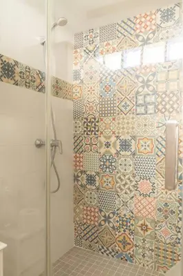 a shower with a glass door with tiles on the wall at Columela by Gades Gestión in Cádiz