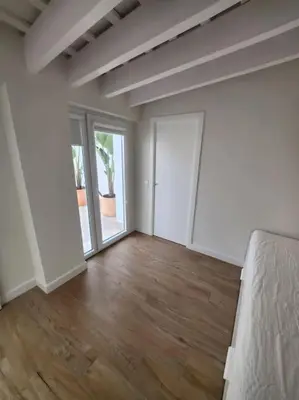 an empty room with a bed and a large window at Apartamento Ancha 3 in Sanlúcar de Barrameda