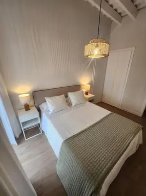 a bedroom with a bed and two night stands and a lamp at Apartamento Ancha 3 in Sanlúcar de Barrameda