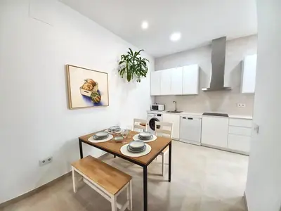 a kitchen with a wooden table and a dining room at Dani Home in Cádiz
