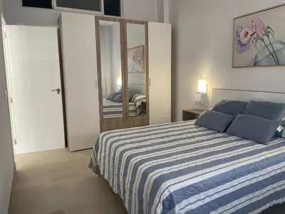 a bedroom with a blue and white bed with a mirror at Dani Home in Cádiz