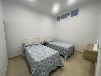 a room with two beds and a table in it at Dani Home in Cádiz