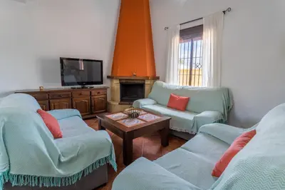 a living room with two chairs and a tv at EntreCalas 4 Chalet con piscina privada en Conil, cala aceite, Roche viejo in Conil de la Frontera
