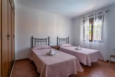 two beds in a room with white walls and a window at EntreCalas 4 Chalet con piscina privada en Conil, cala aceite, Roche viejo in Conil de la Frontera