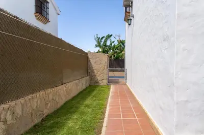 a brick walkway next to a wall with grass at EntreCalas 4 Chalet con piscina privada en Conil, cala aceite, Roche viejo in Conil de la Frontera