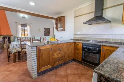 a kitchen with wooden cabinets and a stove top oven at EntreCalas 4 Chalet con piscina privada en Conil, cala aceite, Roche viejo in Conil de la Frontera