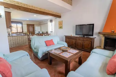 a living room with a couch and a tv at EntreCalas 4 Chalet con piscina privada en Conil, cala aceite, Roche viejo in Conil de la Frontera
