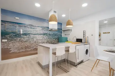 a kitchen with a large painting of the ocean at Apartoyou - Polvorista Puerto in El Puerto de Santa María
