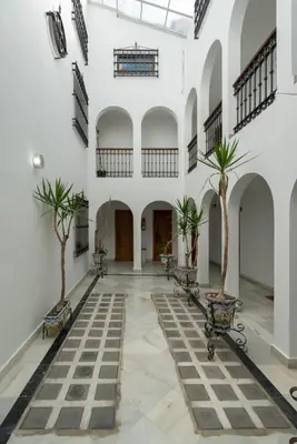 a courtyard with two palm trees in a building at Apartoyou - Polvorista Puerto in El Puerto de Santa María