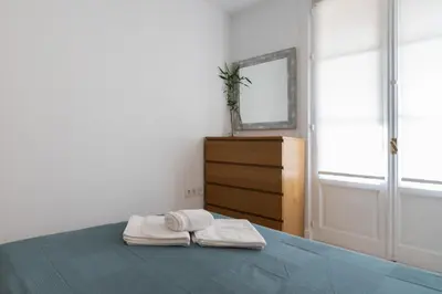 a bedroom with a bed with two towels on it at Apartoyou - Polvorista Puerto in El Puerto de Santa María
