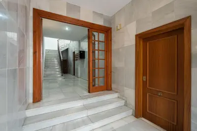 a hallway with a wooden door and stairs at Apartoyou - Polvorista Puerto in El Puerto de Santa María