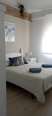 a bedroom with a bed with two pillows on it at Dúplex Casa Ana Apartaclub La Barrosa in Chiclana de la Frontera