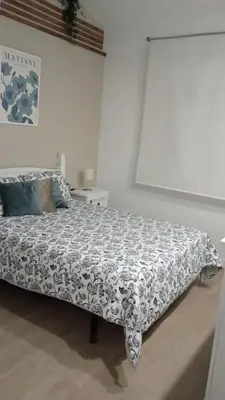 a bedroom with a bed with a black and white comforter at Dúplex Casa Ana Apartaclub La Barrosa in Chiclana de la Frontera