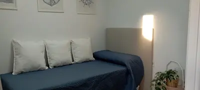 a bed with two pillows and a blue blanket at Dúplex Casa Ana Apartaclub La Barrosa in Chiclana de la Frontera
