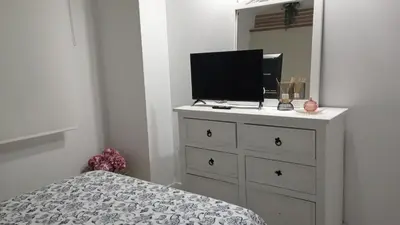 a bedroom with a dresser with a television on it at Dúplex Casa Ana Apartaclub La Barrosa in Chiclana de la Frontera