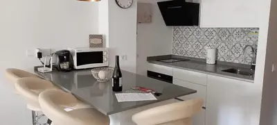 a kitchen with a table with chairs and a microwave at Dúplex Casa Ana Apartaclub La Barrosa in Chiclana de la Frontera