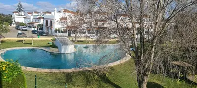 a swimming pool in a yard next to a house at Dúplex Casa Ana Apartaclub La Barrosa in Chiclana de la Frontera