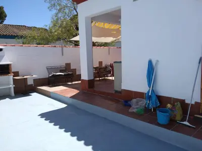 a patio with a table and chairs on a house at Chalet Aquí No Es in Chiclana de la Frontera