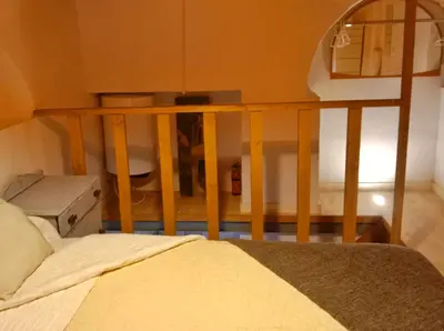 a bedroom with a bed with a wooden railing at Apartamento Buhardilla Cruz Vieja in Jerez de la Frontera