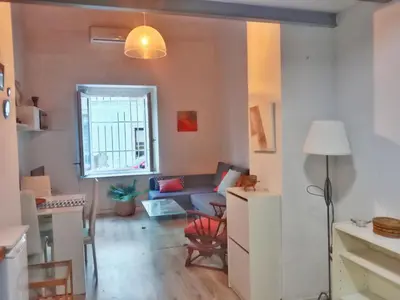 a living room with a blue couch and a window at Apartamento Buhardilla Cruz Vieja in Jerez de la Frontera
