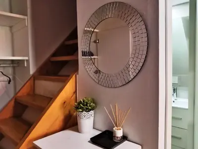 a mirror on a wall above a table with a sink at Apartamento Buhardilla Cruz Vieja in Jerez de la Frontera