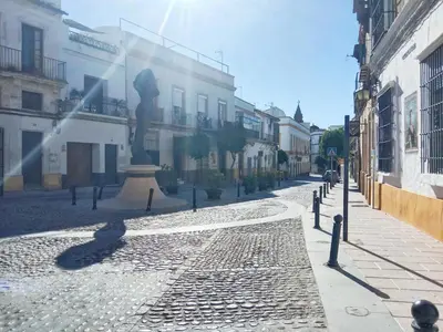a cobblestone street with a statue in the middle at Apartamento Buhardilla Cruz Vieja in Jerez de la Frontera