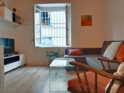 a living room with a couch and a tv at Apartamento Buhardilla Cruz Vieja in Jerez de la Frontera