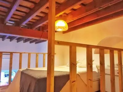 a bed in a room with a wooden ceiling at Apartamento Buhardilla Cruz Vieja in Jerez de la Frontera