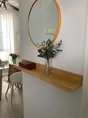 a vase of flowers on a counter with a mirror at Apartamento Rota Progreso 5 in Rota