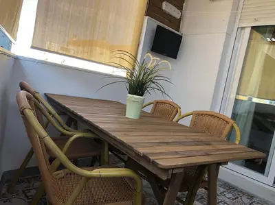 a wooden table with chairs and a potted plant on it at Apartamento Rota Progreso 5 in Rota