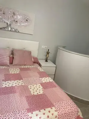 a bedroom with a pink bed with a pink blanket at Apartamento Rota Progreso 5 in Rota