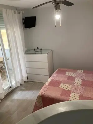 a bedroom with a bed and a dresser with a tv at Apartamento Rota Progreso 5 in Rota