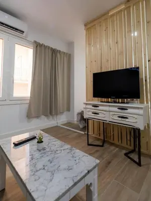 a living room with a tv and a table at SH Loft del Mar. Cerca de la playa y el centro. AC in Cádiz