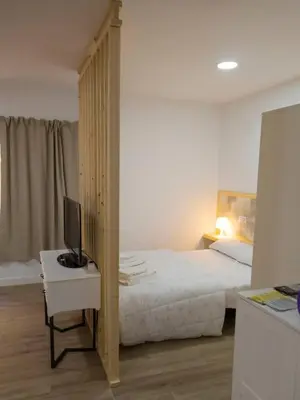 a bedroom with a bed and a desk with a television at SH Loft del Mar. Cerca de la playa y el centro. AC in Cádiz