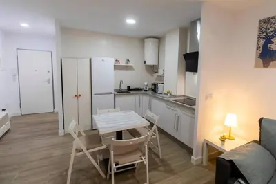 a kitchen and living room with a table and chairs at SH Loft del Mar. Cerca de la playa y el centro. AC in Cádiz