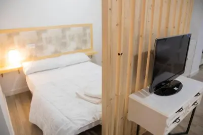 a small bedroom with a bed and a tv on a desk at SH Loft del Mar. Cerca de la playa y el centro. AC in Cádiz