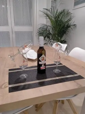 a bottle of wine and two glasses on a table at Apartamento las tres lunas in Sanlúcar de Barrameda