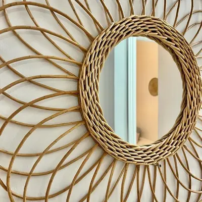 a mirror on a wall with a w rattan mirror at Apartamento las tres lunas in Sanlúcar de Barrameda