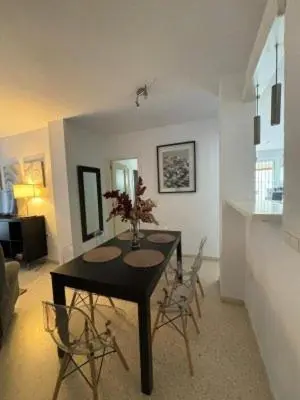 a dining room with a table and chairs in a living room at RESIDENCIAL EN BAJO DE GUIA in Sanlúcar de Barrameda