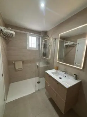 a bathroom with a shower and a sink and a mirror at RESIDENCIAL EN BAJO DE GUIA in Sanlúcar de Barrameda