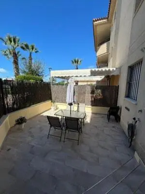a patio with a table and chairs and an umbrella at RESIDENCIAL EN BAJO DE GUIA in Sanlúcar de Barrameda