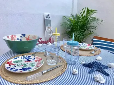 a table with plates of food and a bowl on it at Apartamento con porche y piscina in Chiclana de la Frontera