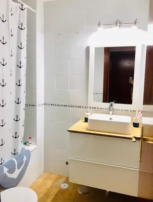a bathroom with a sink and a mirror at Apartamento con porche y piscina in Chiclana de la Frontera