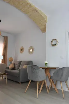 a living room with a couch and a table at CAPILLITA XXI APARTAMENTOS in Sanlúcar de Barrameda
