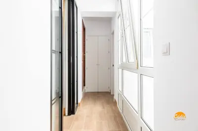 a hallway with white walls and a wooden floor at Mar de la Viña - Free Parking by Cádiz Time in Cádiz