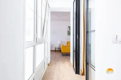 a hallway with a yellow couch in a room at Mar de la Viña - Free Parking by Cádiz Time in Cádiz